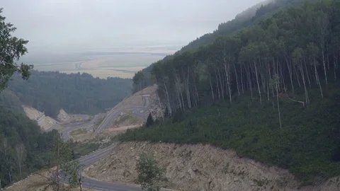 View from the top of curving mountain road Stock Footage 80017576
