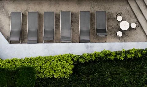 View from the top at deck chairs, table, chairs, and plants. Stock Photos