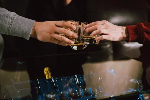 View from the top. Hands of people with glasses of whiskey or wine, celebrati Stock Photos
