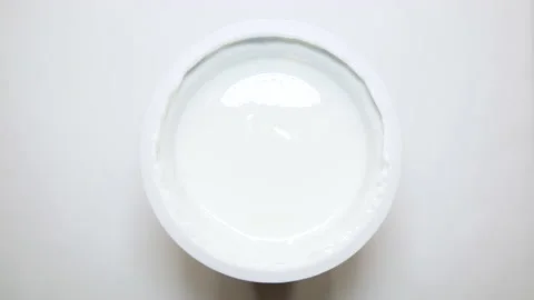 View from top jar with yogurt isolated on white background. Eat spoon close up Stock Footage 130816059