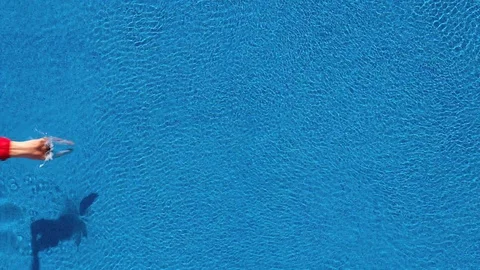 View from the top as a man dives into the pool and swims under the water Stock-Footage 114515414
