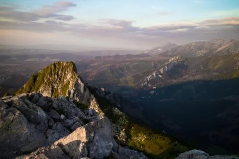 View from the top of Mount Giewont to the cliffs and mountains at sunset Stock Photos