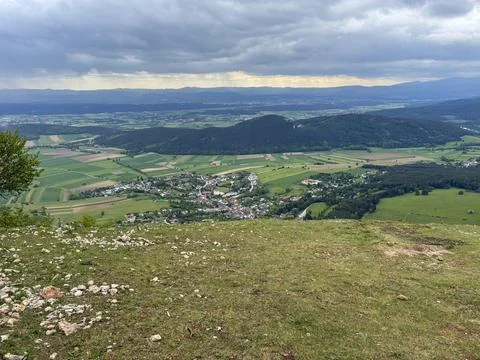 View from the top of a mountain overlooking a small village and farmland du.. Stock Photos