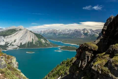 View from the top of mountain ridge looking down on colourful alpine lake and mo Stock Photos