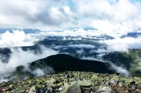 View from the top of the mountain, stony ground, morning mist and clouds Fotos de archivo