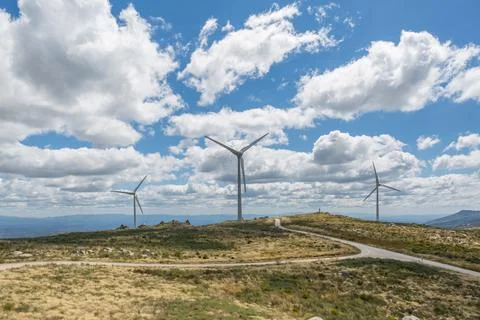 View of a top mountains landscape with a wind turbines, green herb fields Stock Photos