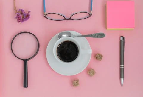 View from the top of a set of items with a cup of coffee on a pink background Stock Photos