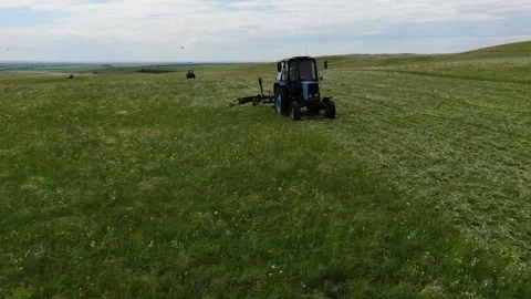 The view from the top. The tractor in the field to mow the grass. panorama down Stock Footage 132719400