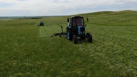 The view from the top. two tractors in the field to mow the grass. animal feed Stock Footage 132719397