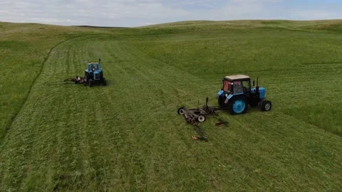 The view from the top. two tractors in the field to mow the grass. animal feed Stock Footage 132719420