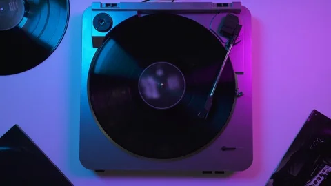 View from top: Vinyl record player on the table in blue and violet neon lights 動画素材 116630589