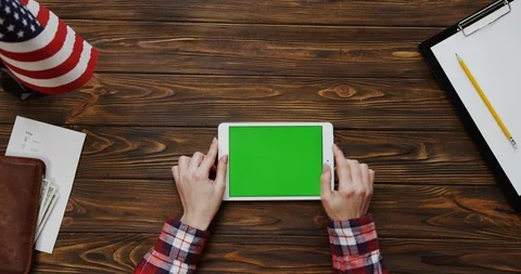 View from the top on the woman's hands scrolling and taping on the white tablet Stock Footage 91717710