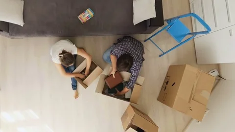 View from the top on young family moving in new house and unpacking boxes Stock Footage
