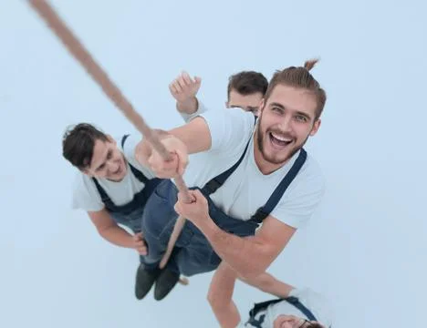 View from the top.smiling engineer ,climbing up the rope Stock Photos