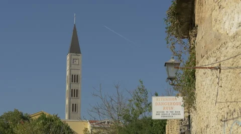 View of the tower of  the Catholic church and a warning sign in Mostar Stock Footage 59432224