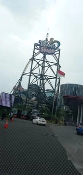 A view of a tower that says Trans Studio, in the front parking area Stock Photos