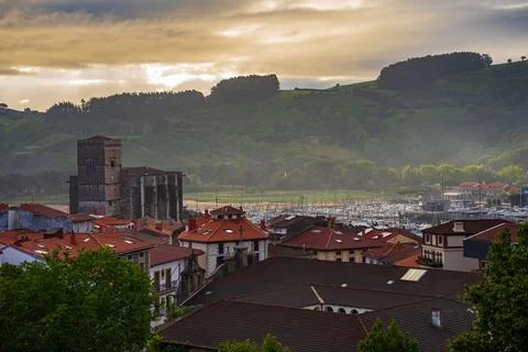 View of the tower of St. Peter the Apostole Parish in Zumaia. Tiled roofs of an Stock Photos