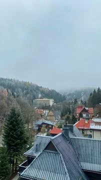 View of a town surrounded by mountains on a cloudy day with various buildin.. Stock-Fotos