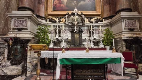 View of a traditional Catholic side altar with lit candles and religious statues Stock Footage 338010292
