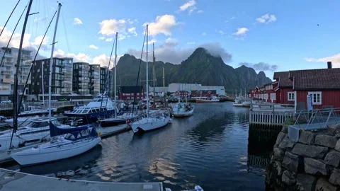 View of traditional red rorbuer cabins and sailboats in Svolvaer harbour Lofoten Stock-Footage 343834200
