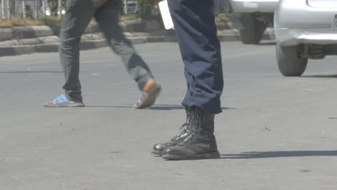 View of a traffic man below his waist holding a car plate on his hand Stock Footage 108847270