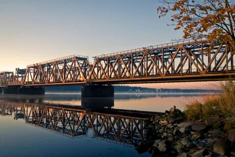 The view on train bridge above the river during sunrise. Stock Photos