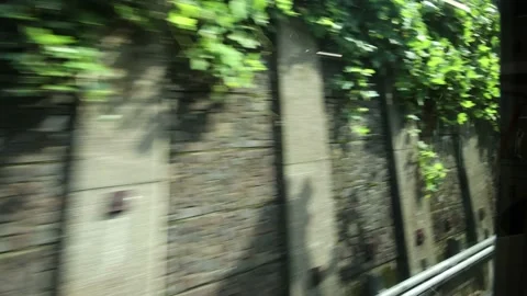 View from train in Tokyo Japan. Concrete wall to green bush. Stock Footage 220097512
