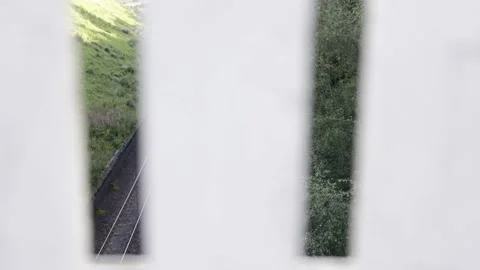 A view of train tracks through a white fence. Stock Footage 159370295