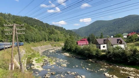 A view of a train with wagons passing through the mountains Stock Footage 250995907
