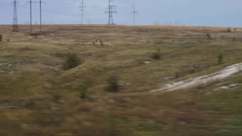 View from the train window of a field and power lines, beautiful nature Stock Footage 315513823