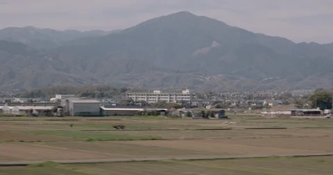 View from train window, Japan ,fields with houses, mountains at backround. Stock Footage 119309660