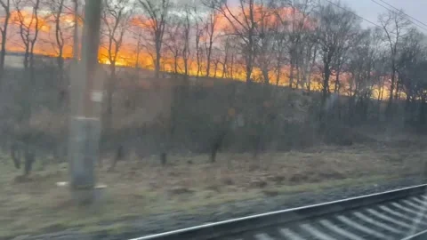 A view from the train window of a magical sunset in the sky Stock Footage 235617435