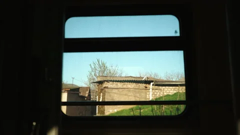 View from train window in motion - sun shines through trees silhouette Stock Footage 180056694