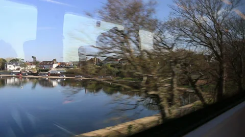 View from a train window passing lake and houses Stock Footage 37222848