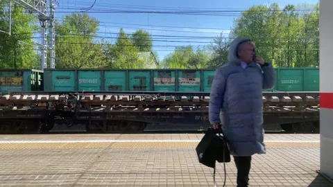 View from the train window on the passing landscape and the station and people Stock Footage 196010414