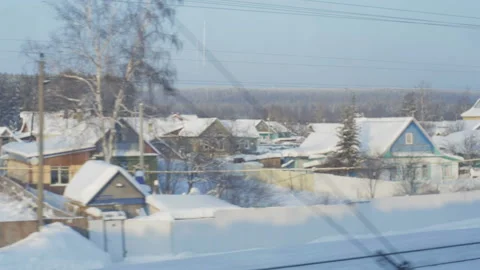 View from the train window passing by the village in winter Stock Footage 104701650