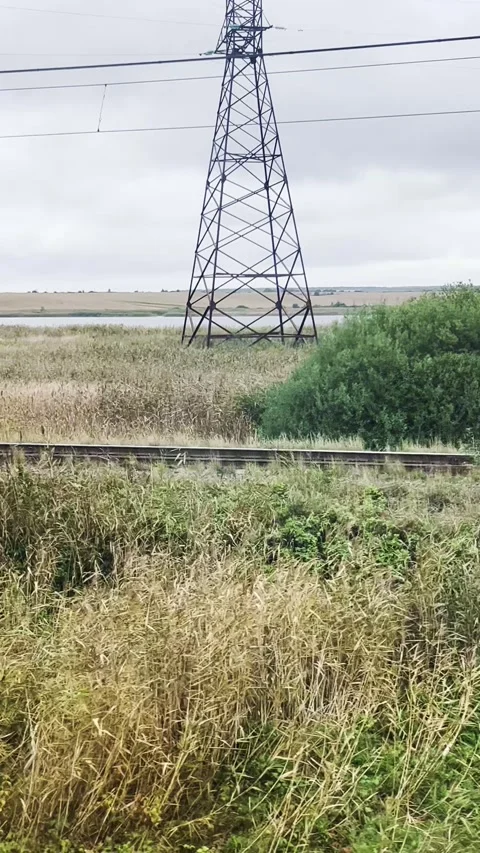View from the train window of power lines and railroad tracks. Vertical video.	 Stock Footage 299708422