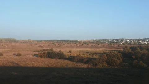 View from train window showing expansive autumn landscape with brown fields, Stock Footage 339866069