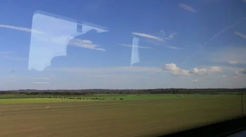 View from a train window trees green fields blue sky Stock Footage 37224481
