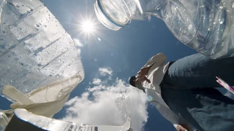 The view from the trash heap. POV: A man finishes his water from a plastic Stock Footage 247129125