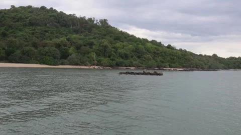 A view of tree-covered mountains with a beach and the sea in Rayong, Thailand Stock Footage 310169799