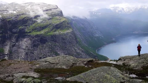 View from Trolltunga over blue Norwegian Fjord with tall surrounding mountains Stock Footage 252692019