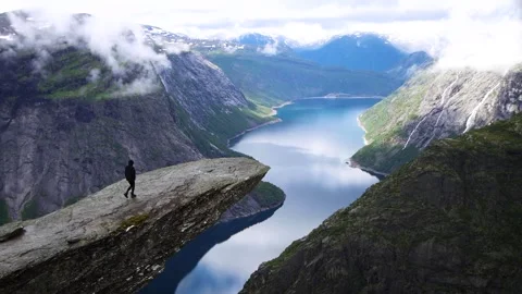 View from Trolltunga over blue Norwegian Fjord with tall surrounding mountains Stock Footage 252692060