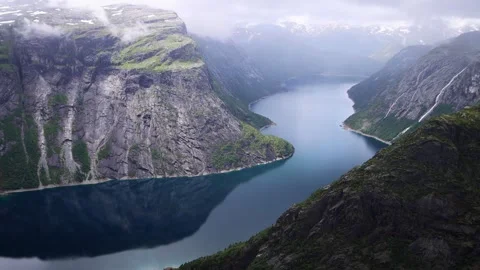 View from Trolltunga over blue Norwegian Fjord with tall surrounding mountains Stock Footage 252692400