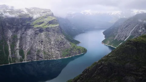 View from Trolltunga over blue Norwegian Fjord with tall surrounding mountains Stock Footage 252693667