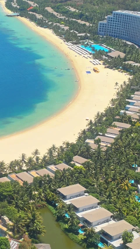 View of a tropical beach resort with palm trees and turquoise sea waves Stock Footage 344629495