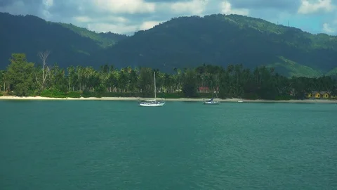 View on Tropical Island with Palm Forest and Mountains 4K.Yachts, boats in Ocean Stock Footage 108627652