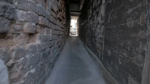 VIEW TROUGH DARK TIGHT GATEWAY IN THE CITY WALK THROUGH TUNEL, PASSAGEWAY Stock Footage 112228653