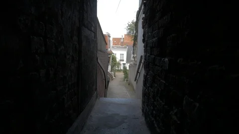 VIEW TROUGH DARK TIGHT GATEWAY IN THE CITY WALK THROUGH TUNEL, PASSAGEWAY Stock Footage 112228680