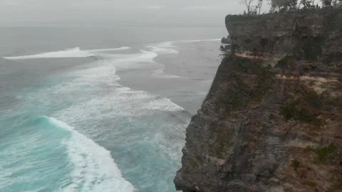 View of the turquoise long waves going to the beach and the view of mighty cliff Stock Footage 130546093